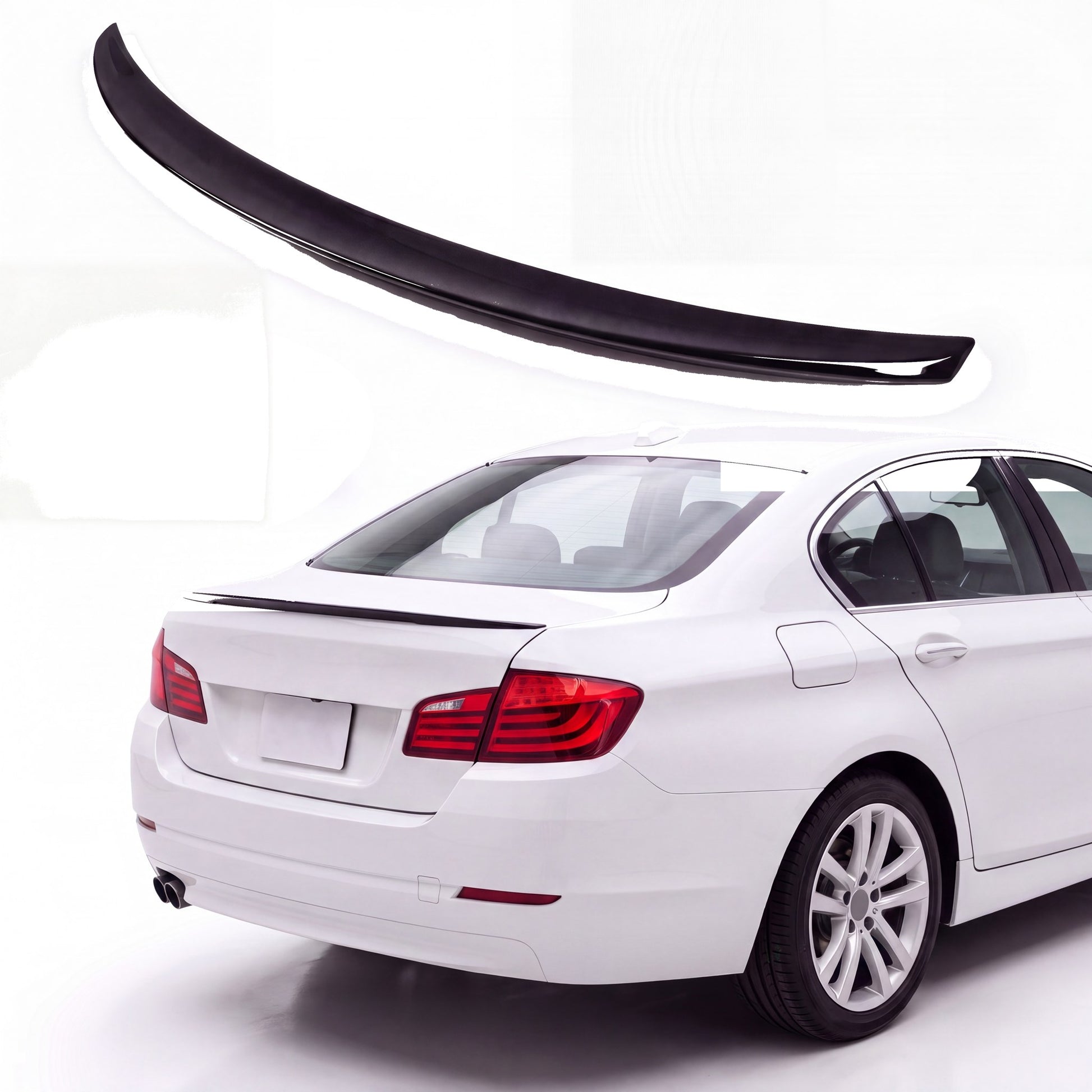 Gloss black trunk lip spoiler on white BMW 5 Series F10 sedan rear three-quarter view