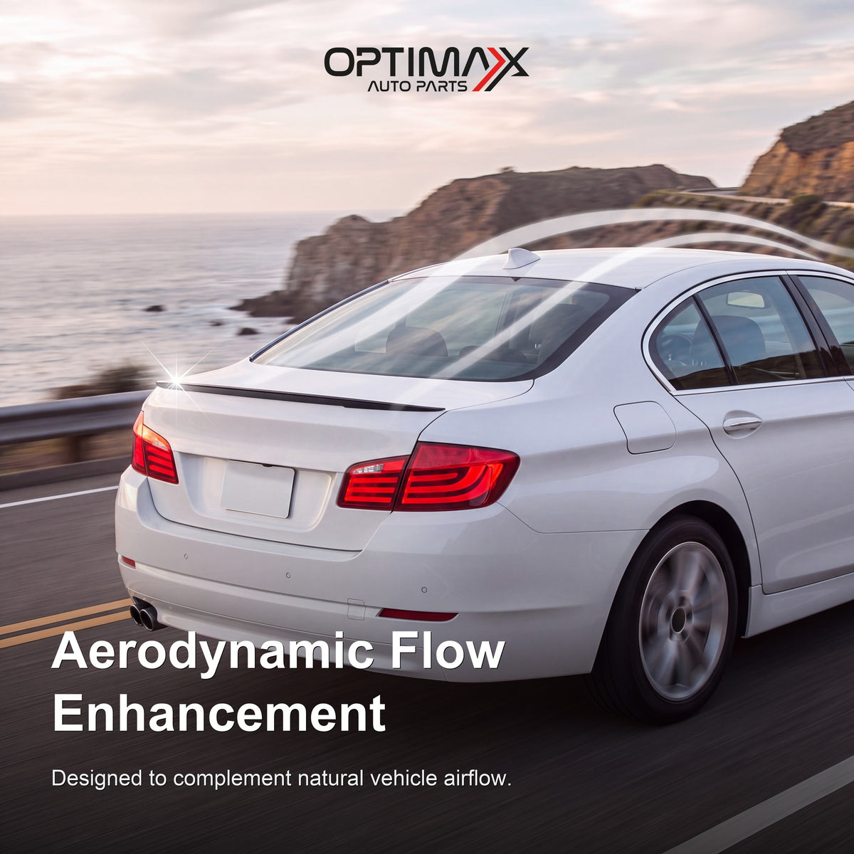 Gloss black trunk lip spoiler on white BMW 5 Series F10 sedan aerodynamic flow enhancement on coastal road