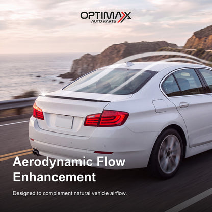 Gloss black trunk lip spoiler on white BMW 5 Series F10 sedan aerodynamic flow enhancement on coastal road