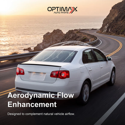 Gloss black trunk lip spoiler on white Volkswagen Jetta MK5 sedan aerodynamic flow enhancement on coastal road