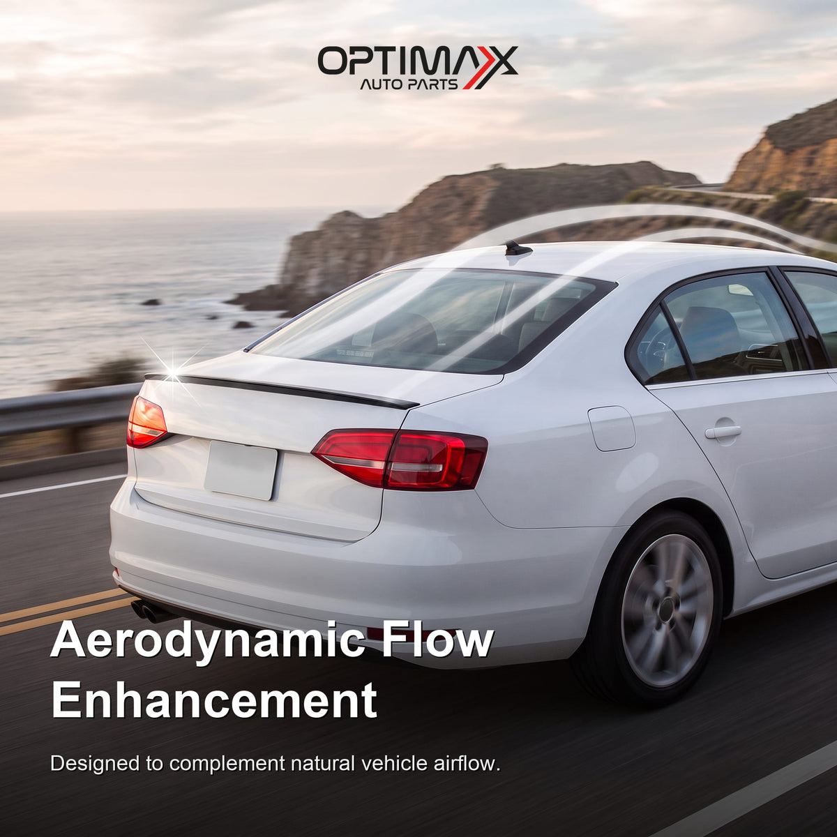 Gloss black trunk lip spoiler on white Volkswagen Jetta MK6 sedan aerodynamic flow enhancement on coastal road