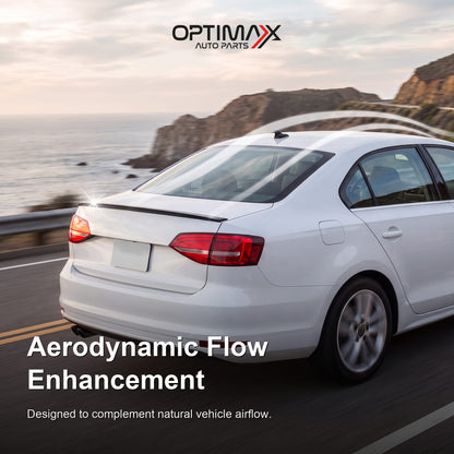Gloss black trunk lip spoiler on white Volkswagen Jetta MK6 sedan aerodynamic flow enhancement on coastal road