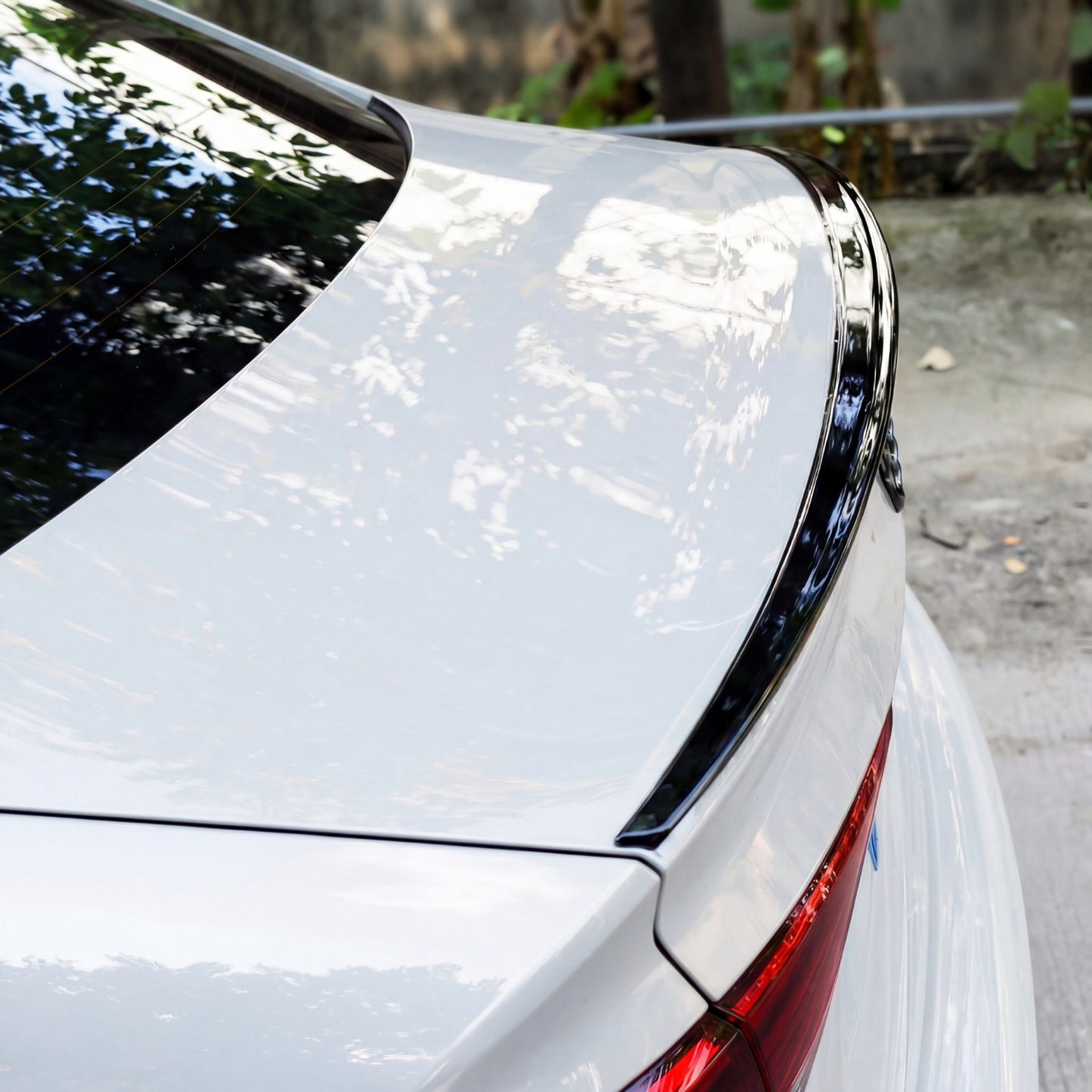 Trunk lip spoiler installed on white sedan trunk lid