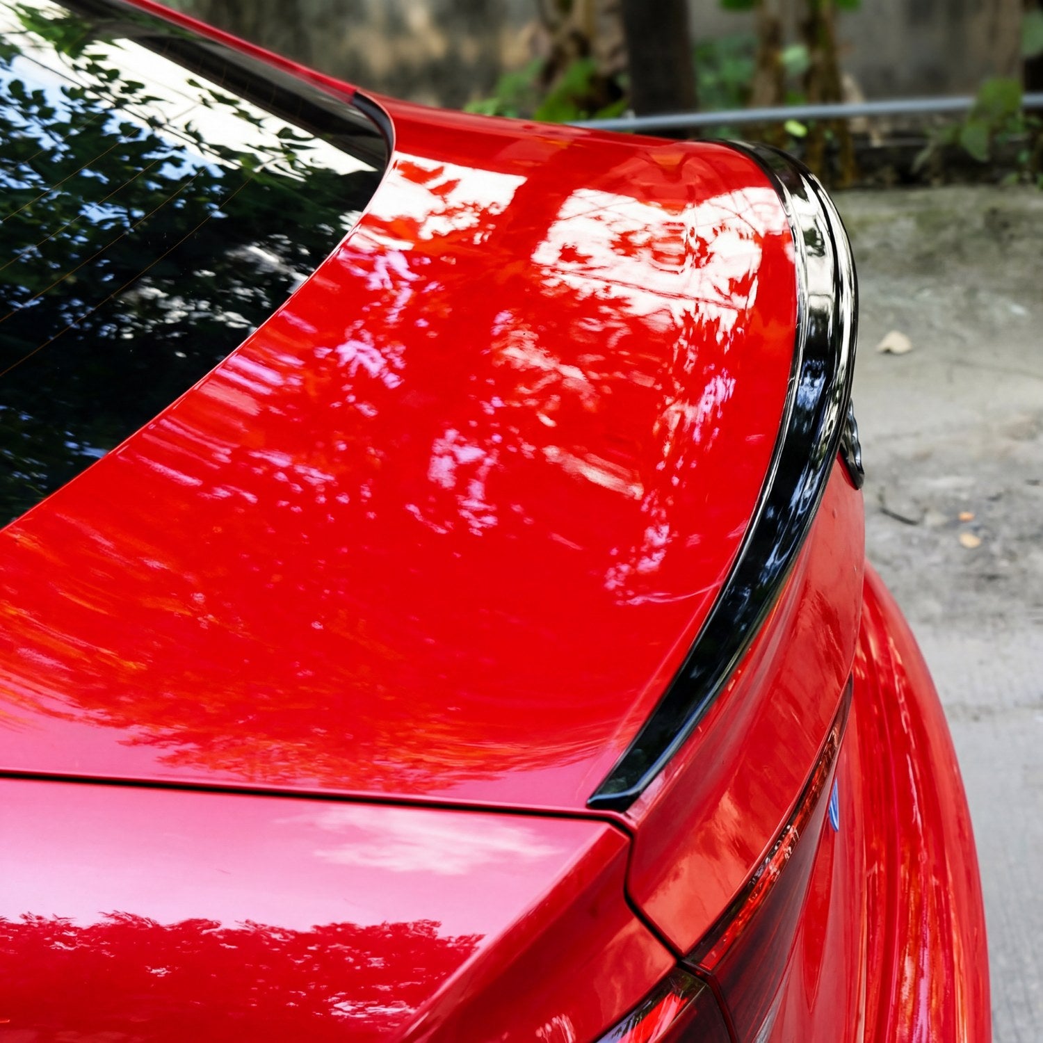 Trunk lip spoiler installed on red sedan trunk lid